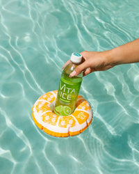 Hand holding a bottle of Vita Ice on an inflatable ring in clear water