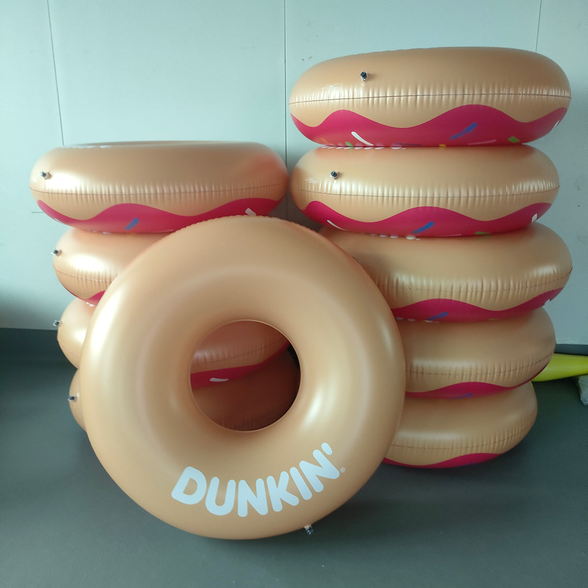 Inflatable donut rings with 'Dunkin' branding on a plain background