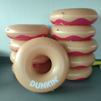Inflatable donut rings with 'Dunkin' branding on a plain background