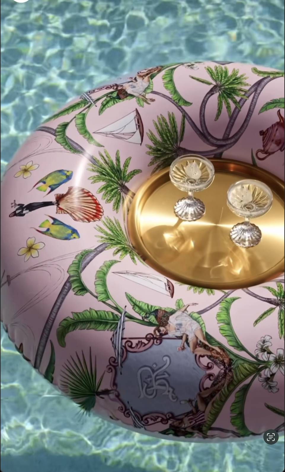 Decorative object with gold elements and floral design on a pink background