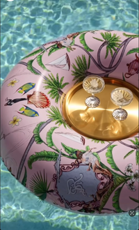 Decorative object with gold elements and floral design on a pink background