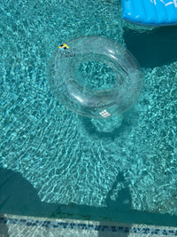 Clear inflatable ring floating in a pool with clear water