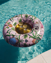 Decorative inflatable pool float with a floral pattern and gold center floating in clear blue water.