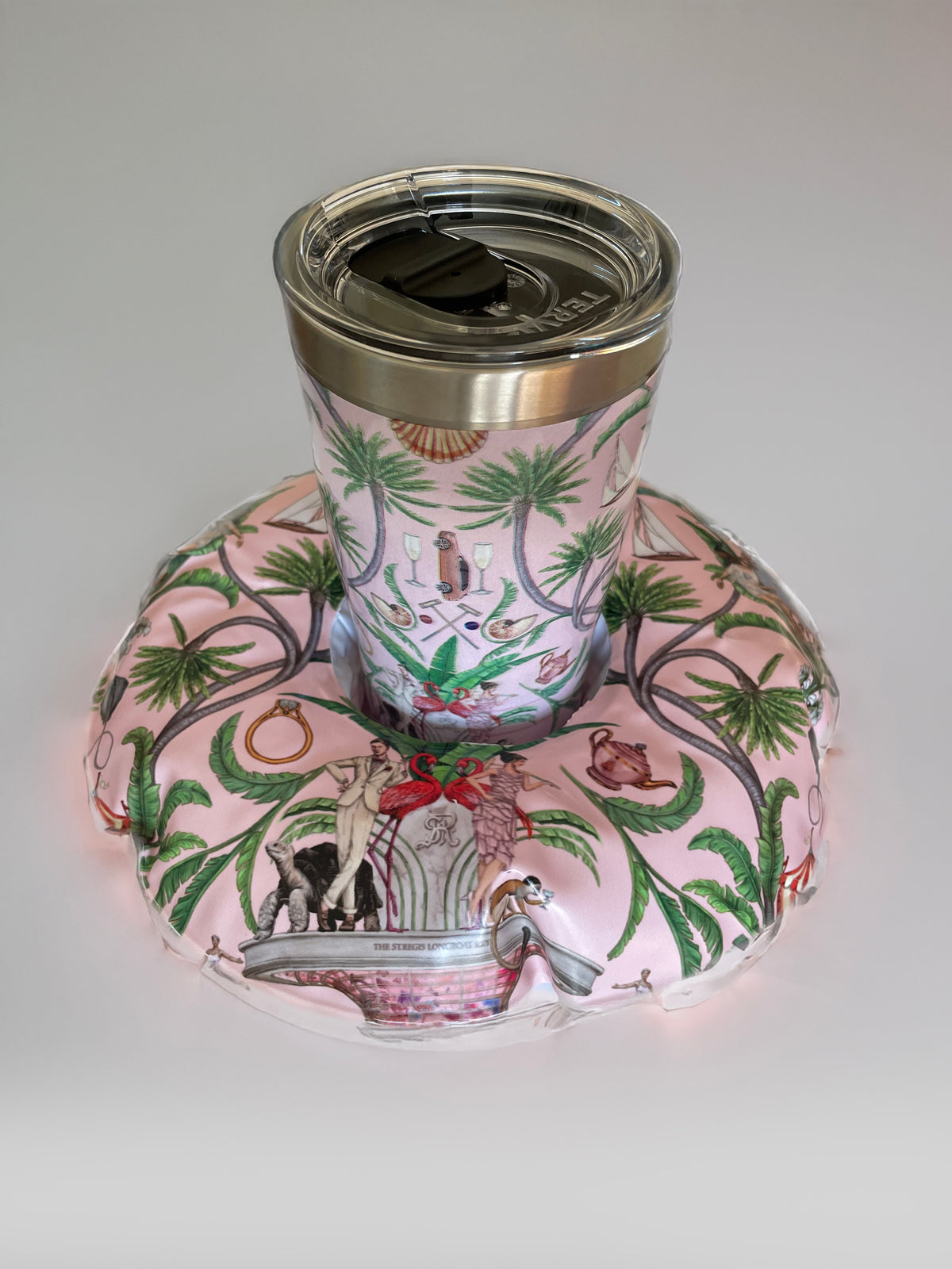 Tumbler with floral design on a matching pink coaster on a white background