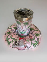 Tumbler with floral design on a matching pink coaster on a white background