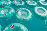 Multiple inflatable rings with Pepsi logo on a blue background
