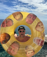 Inflatable pool float with faces on a background of water and sky