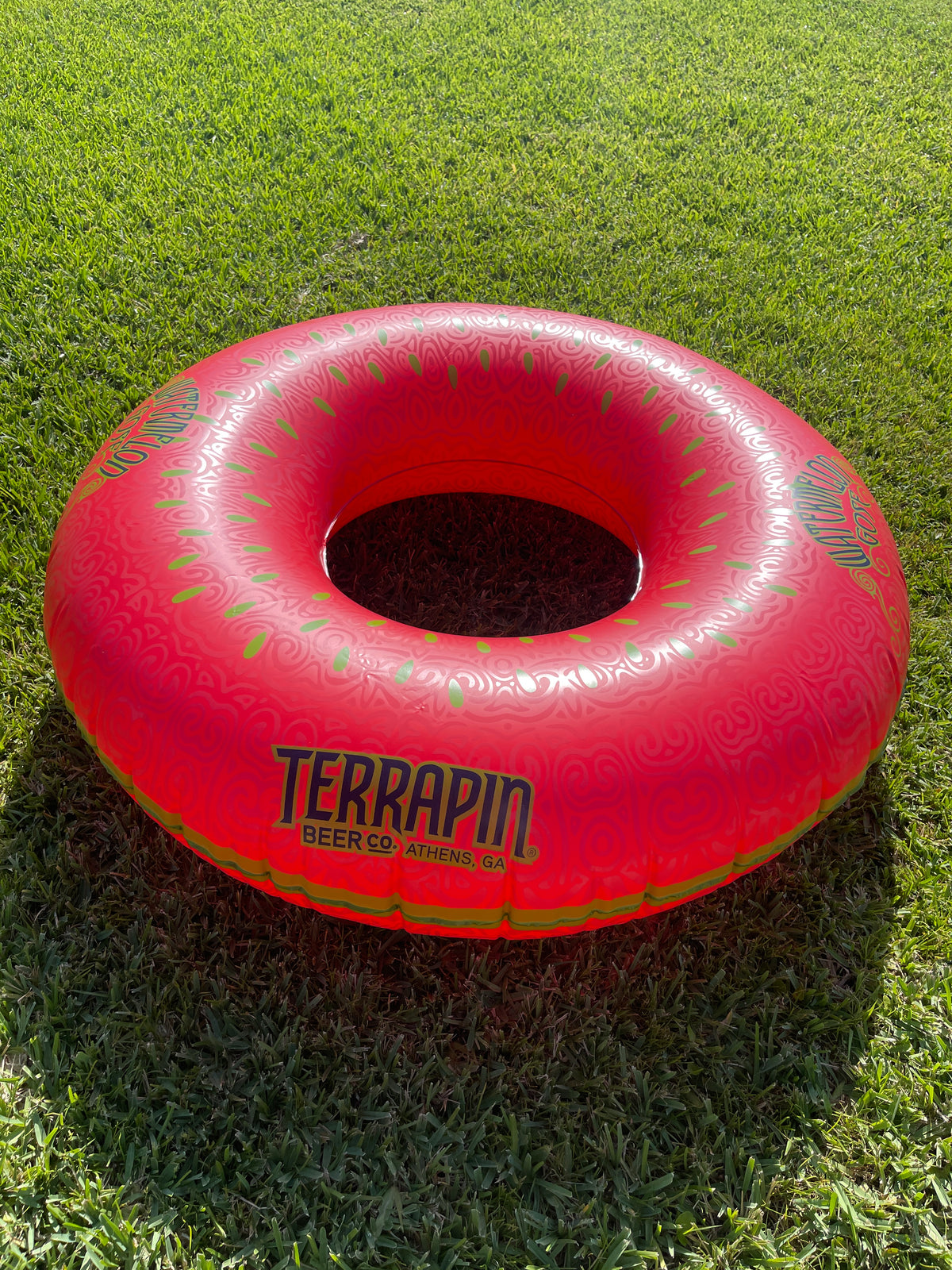 Red inflatable donut toy with 'Terrapin' branding on grass