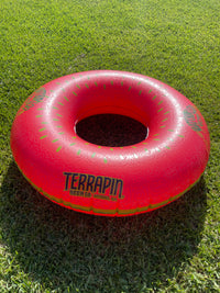 Red inflatable donut toy with 'Terrapin' branding on grass