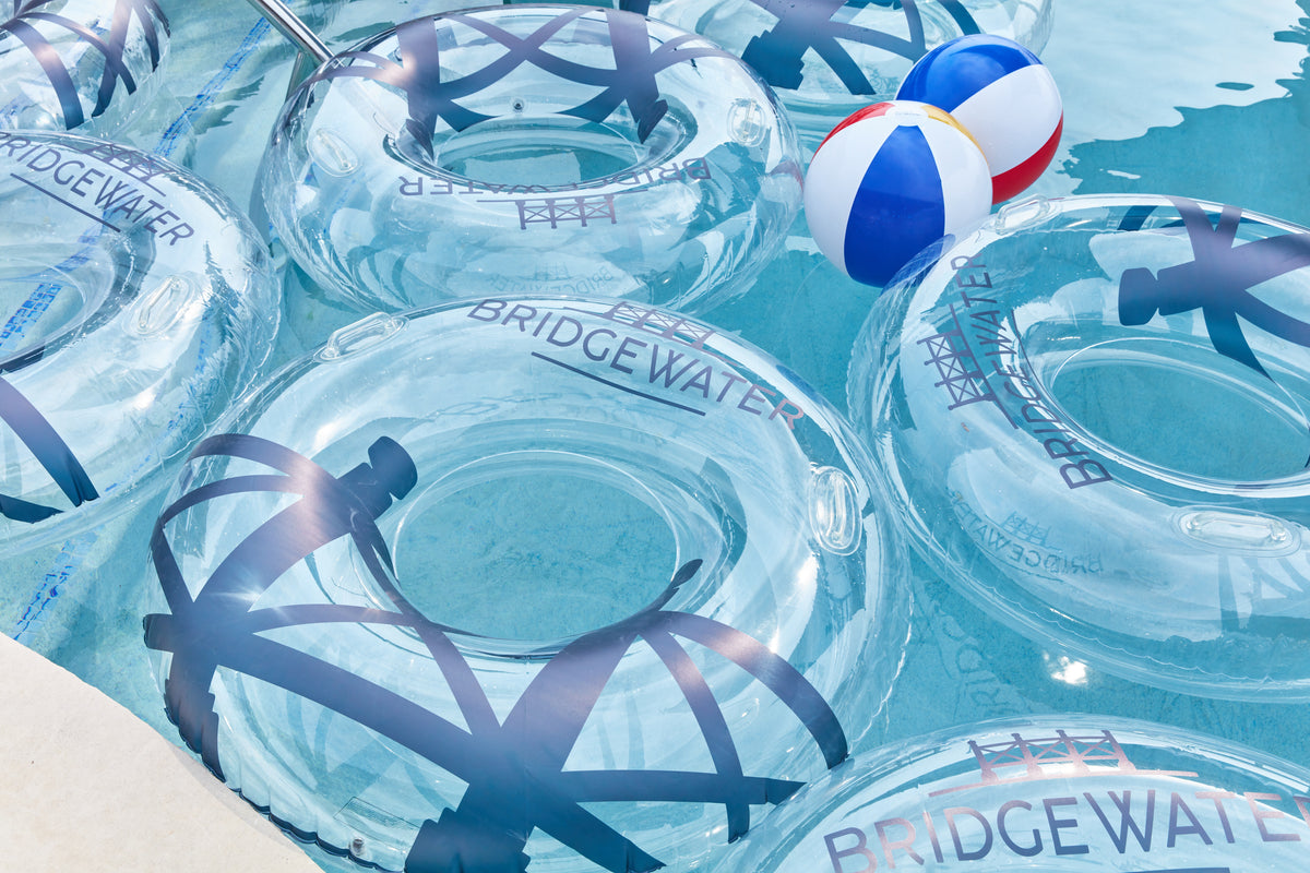 Clear inflatable rings with 'Bridgewater' branding in a pool with a beach ball.