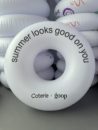 White inflatable ring with text 'summer looks good on you' and 'Coterie x goop' branding.